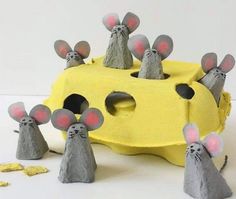 some paper mice are standing in front of a piece of yellow and gray material with red eyes