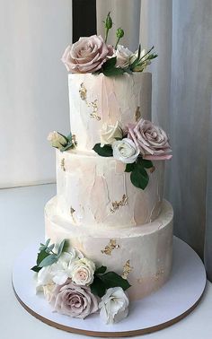 a three tiered wedding cake with pink and white flowers