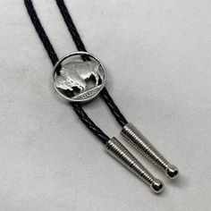 "This bolo tie features a buffalo nickel cut out by hand as the clasp on the tie and a tip design of your choice. Made just for the true cowboys who like to roll in style. The cord is 3mm leather at a length of 38\". If you prefer a different length, please message me.  Please note that due to the fact each coin is genuine and each button handmade, there may be some variation from the picture.  If you have a special coin that you are looking for, please do not hesitate to contact me as I love to do custom too." Silver Quarters, Bolo Ties, Buffalo Nickel, Bezel Ring, Coin Ring, Bolo Tie, Garage Design, Tie Accessories, Suit And Tie