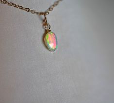 Choose from a selection of five unique opal charms crafted from 14K solid gold and opal, each adorned with an accent gemstone. The opals and gemstones used are all natural, complemented by the addition of 14K gold beads for a touch of elegance. Please note that the chain is not included with this pendant. Teardrop Ethiopian Opal Jewelry Gift, Dainty Ethiopian Opal Birthstone Jewelry, Gold Ethiopian Opal Birthstone Ring, Gold Teardrop Opal Ring Gift, Gold Oval Pink Opal Jewelry, Green Opal Birthstone Jewelry, Gold Teardrop Opal Ring Perfect For Gifts, Handmade Gold Opal Ring With Ethiopian Opal, Oval Gold Jewelry With Pink Opal