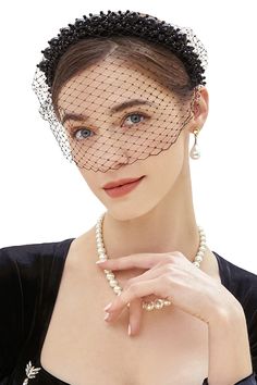 a woman in a black dress wearing a birdcage veil over her head and necklace