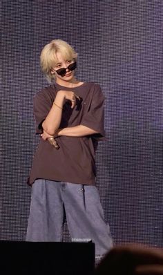 a woman with blonde hair and sunglasses standing on stage