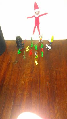 an elf is standing on the floor surrounded by toys