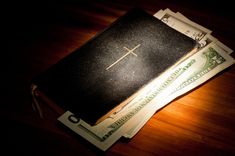 a black bible sitting on top of money