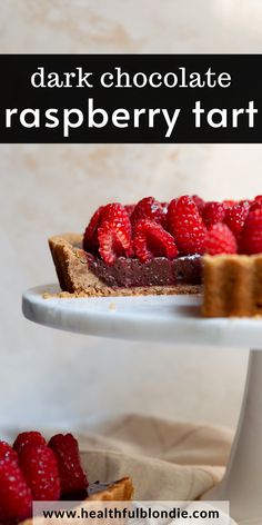 a chocolate raspberry tart on a white cake plate with fresh strawberries