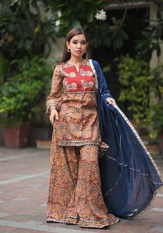 The colors, sight and scent of the mystical garden were so captivating, she wanted to carry it wherever she went!  Our Kadambari 3 piece set comes in 3 color Kalamkari Hand block print of earthly hues on cotton fabric! The stylish silhouette is enhanced with a pichwai style yoke and lots of gotta detailing including the conical tassels on the side.  The Palazzo comes flared that sways with every move of yours!  Additional Information: Fabric: Cotton Cambric Length of the top: 30 inch Length of the sharara: 40 inch Wash Care: Dry Clean. Time to ship: This product will be made for you based on your measurements. It will take up to  2 weeks to ship this. Please note, this product once given for order cannot be returned or canceled as this is a made-to-order product. Size Chart ( Body Measurem Mystical Garden, Cotton Gowns, Sharara Set, Hand Block Print, Satin Skirt, Cotton Skirt, Salwar Kameez, Online Purchase, Block Print