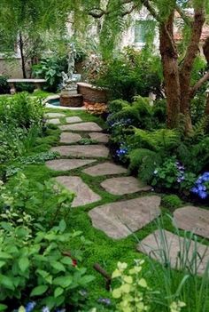 a stone path in the middle of a lush green garden