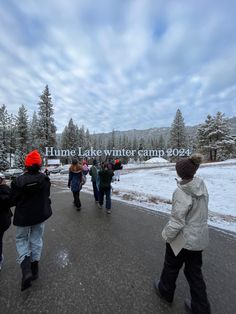 several people walking down the road in front of a sign that says hume lake winter camp 2007