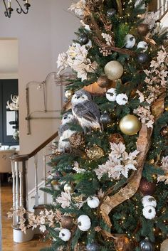 a christmas tree decorated with gold and silver ornaments