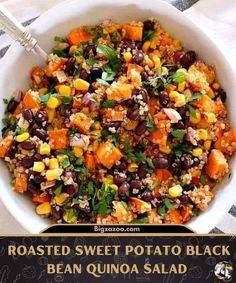 roasted sweet potato black bean quinoa salad in a white bowl with a spoon