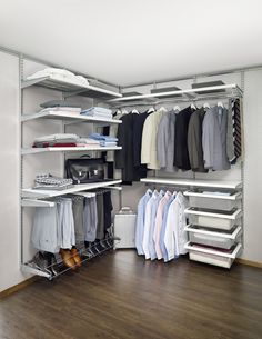 an organized closet with white shelves and clothes hanging on the rails, including shirts and pants