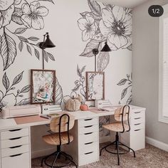 a room with two desks and flowers on the wall