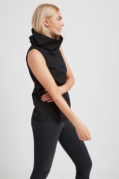 Make a statement with the Marcy Sleeveless Top, a structured and sleek shirt that transforms into a turtleneck. Marcy's unique turtleneck can be worn in two ways — fold in half to wear it gathered at the neckline, or amp up the oversize by standing up the collar for free-form volume. Crafted from 100% European poplin cotton, Marcy provides effortless day-to-night styling possibilities. [SPLIT] Sam, in light beige, is 5'8" (173 cm) tall, wearing size XS. Maritza, in black, is 5'9.5" (177 cm) tall Modern Turtleneck Top For Layering, Black Spring Cowl Neck Tops, Black Cowl Neck Top For Spring, Versatile Cotton Turtleneck Top, Chic High Neck Cotton Tops, Chic Cotton Turtleneck Top, Unique Turtleneck, Sleeveless Collared Shirt, Sleeveless Turtleneck