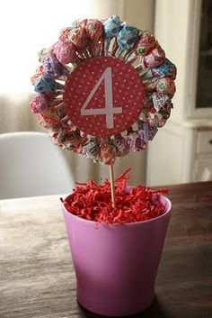 a pink flower pot filled with candy and a number 4 stick on top of it