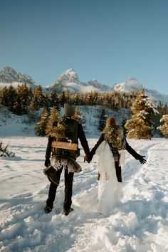 two people walking in the snow holding hands