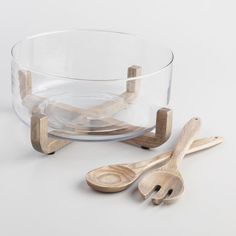 two wooden spoons sitting next to a glass bowl