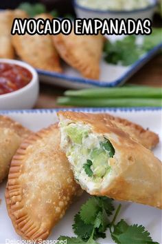 two empanadas on a plate with salsa and cilantro