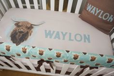 a baby crib with a blue and brown blanket on it's bottom half