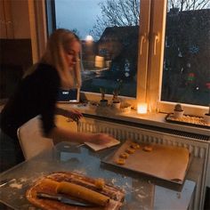 a woman standing in front of a table with food on it