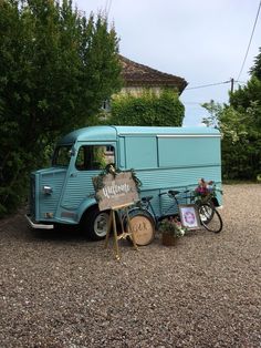 an old blue van is parked in the gravel