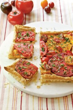 several slices of tomato tart on a plate with tomatoes and cherry tomatoes in the background