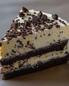 a piece of cake with chocolate chips and cream on top is sitting on a plate