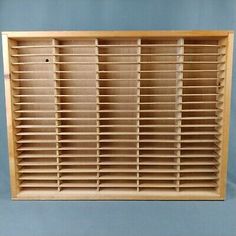 a wooden window with shutters on the outside and inside, in front of a blue wall