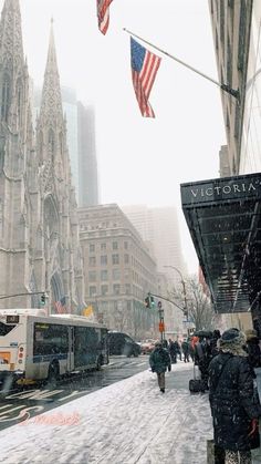 people are walking down the street in the snow