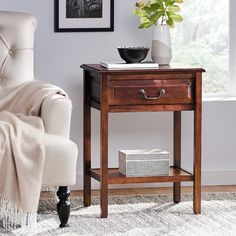 a living room with a white chair and a wooden end table on carpeted floor