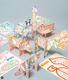 an assortment of cut out paper animals sitting on top of each other with different colors