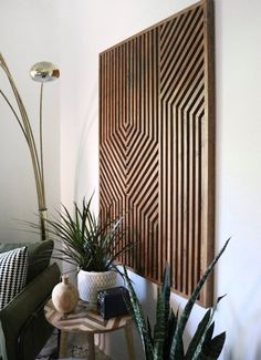 some plants are sitting on a small table in front of a large wooden wall panel