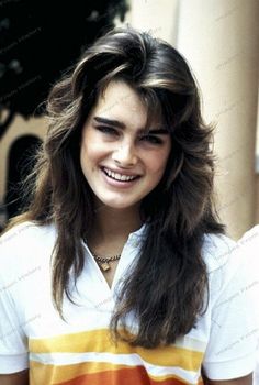 a young woman with long hair smiling at the camera