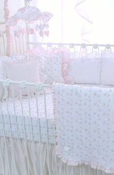 a baby crib with pink and white bedding