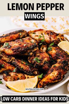 lemon pepper wings on a white plate with lemon wedges