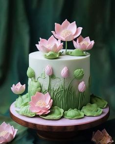 a cake decorated with pink flowers and green leaves