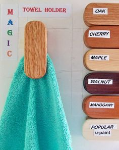 a towel hanging on the wall next to some wooden pegs and magnets with names