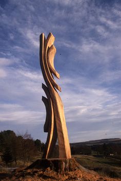 a large wooden sculpture sitting on top of a pile of dirt