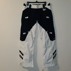 a pair of white and black ski pants hanging on a wall