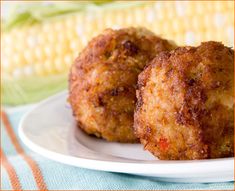 two fried food items on a plate next to corn