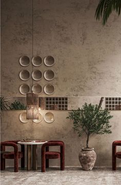 two chairs and a table in front of a wall with circular mirrors on it's sides