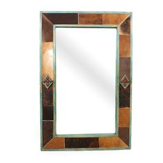 a mirror that is sitting on top of a white wall with a brown and blue border