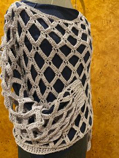 a mannequin is wearing a crocheted shawl