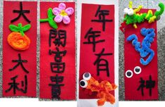 three red banners with chinese characters and flowers on them, each decorated in different colors