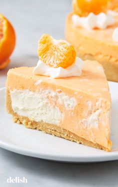 a slice of orange cheesecake on a white plate with an orange in the background