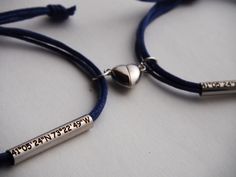 two personalized bracelets are shown on a white surface with blue cords and silver beads