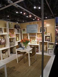 a room filled with lots of white shelves and tables next to each other on display