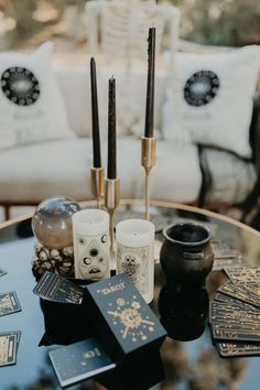 a table topped with candles and cards on top of a glass table