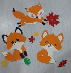 four cut outs of foxes and leaves on a table