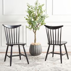 two black chairs sitting next to each other on top of a rug