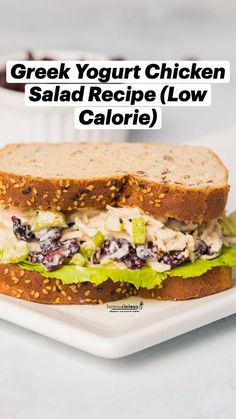 a chicken salad sandwich with lettuce and cranberries on a white plate